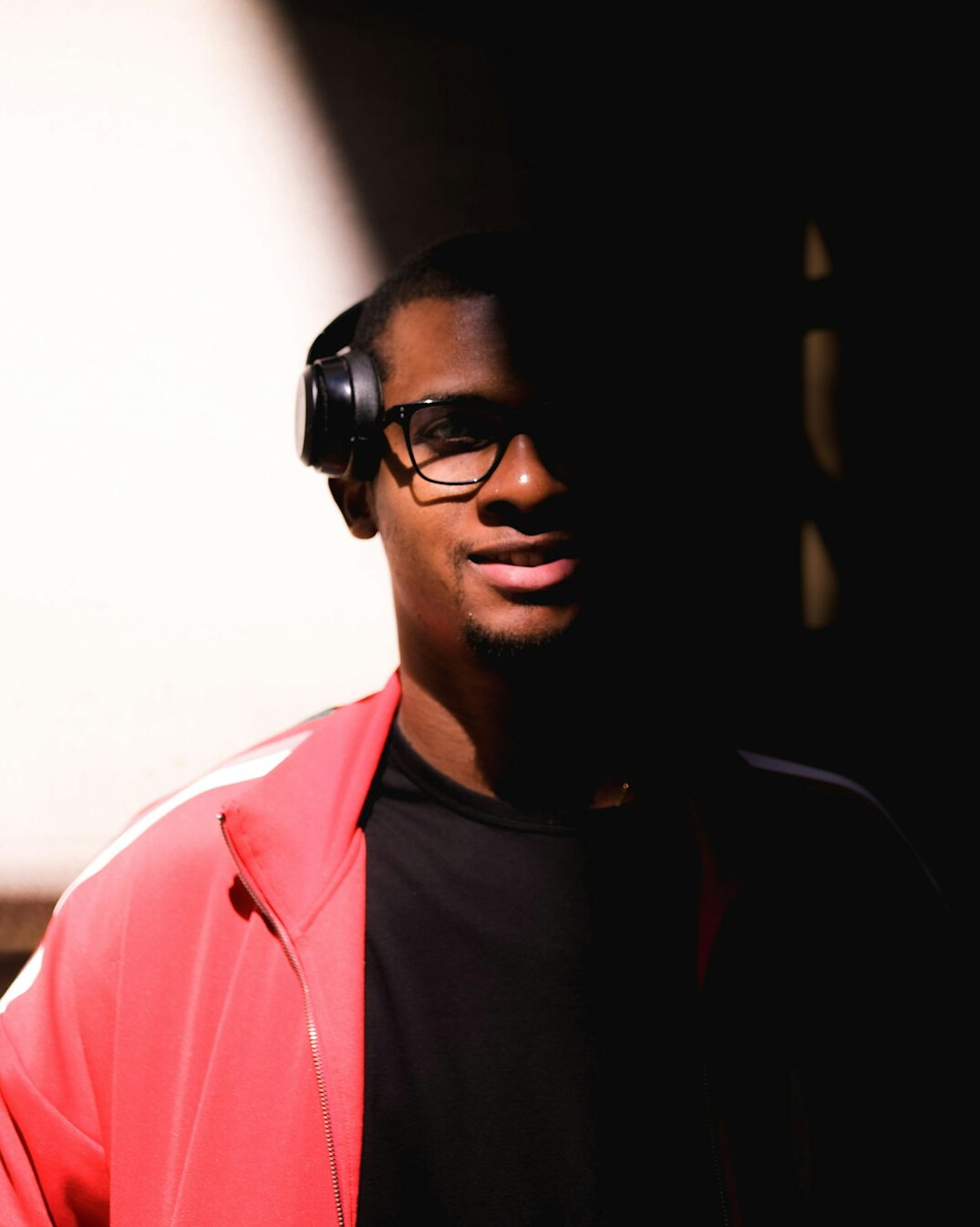 Portrait of a young man with glasses and a headset around his neck