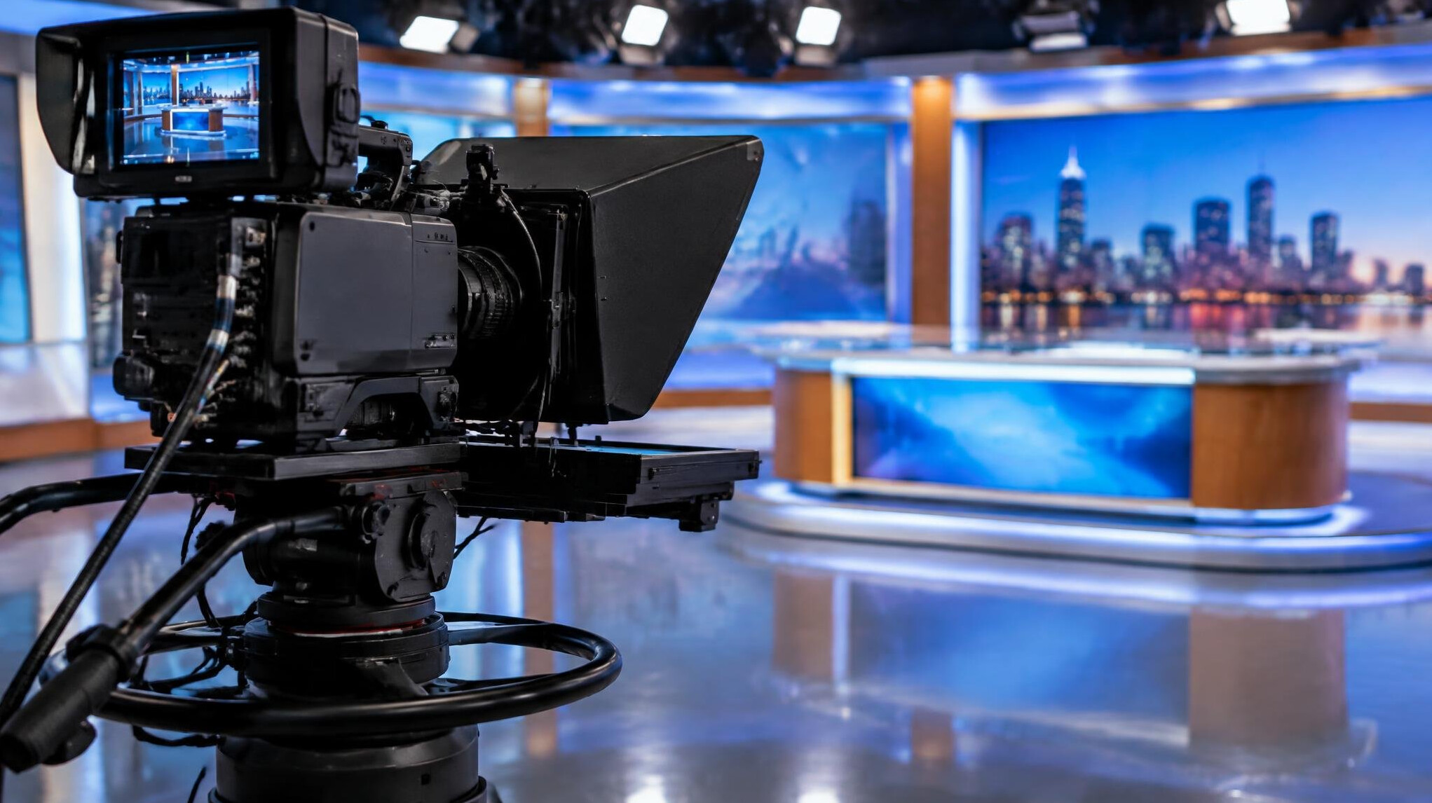 Studio camera on a pedestal pointing at a news set